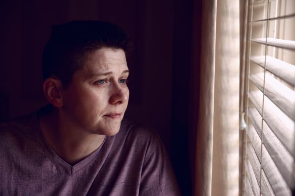 A white masculine-looking person looking out the window.